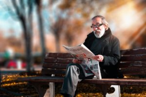 an old man reading newspaper